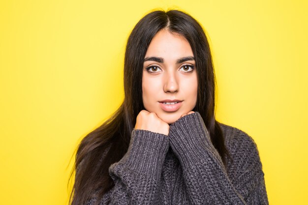 Beautiful young woman sweater smiling, and on yellow.