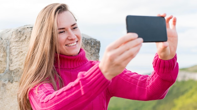 Free Photo beautiful young woman taking a selfie outdoors