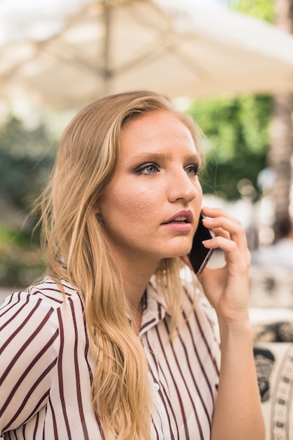 Free photo beautiful young woman talking on cell phone