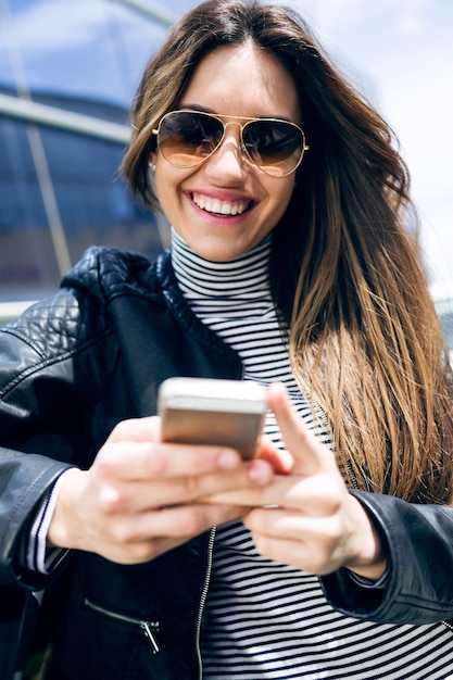 Beautiful young woman using her mobile phone in the car.