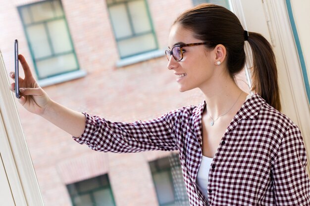 Free Photo beautiful young woman using her mobile phone in the office.