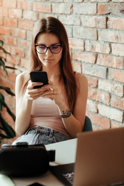 Beautiful young woman using smartphone at home