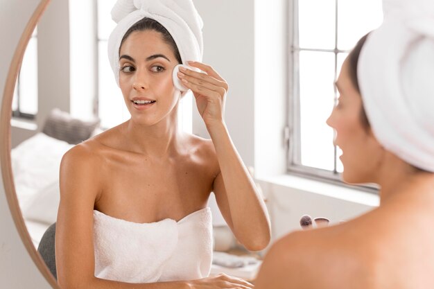 Beautiful young woman using spa products at home