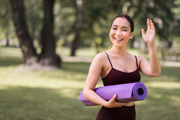 Beautiful young woman waving at someone