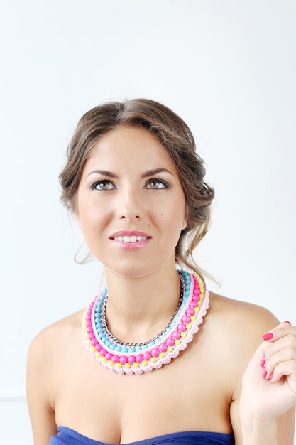 Free Photo beautiful young woman wearing colourful necklace and thinking