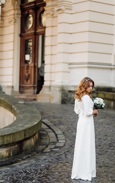 Free Photo beautiful young woman in wedding dress posing on the street in city