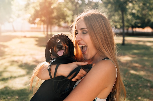 Free photo beautiful young woman with mouth open loving her dog