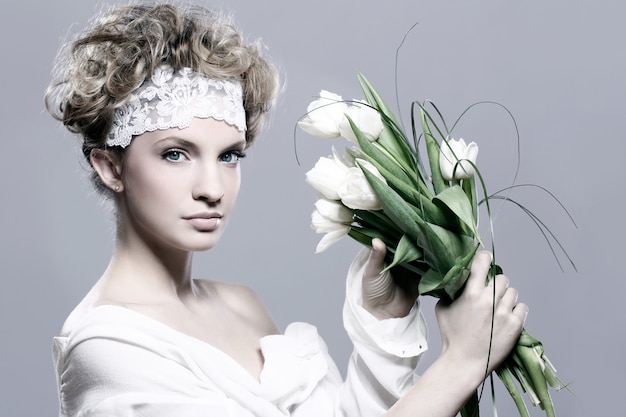 Beautiful young woman with white tulips