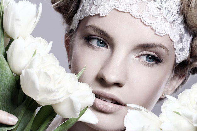 Beautiful young woman with white tulips