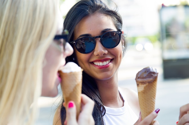 Free photo beautiful young women having fun with ice cream at the park.