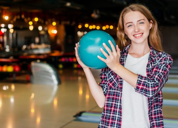 Free photo beautiful young women holding a bowling ball