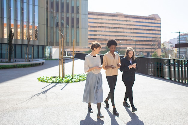 Beautiful young women talking while walking on street