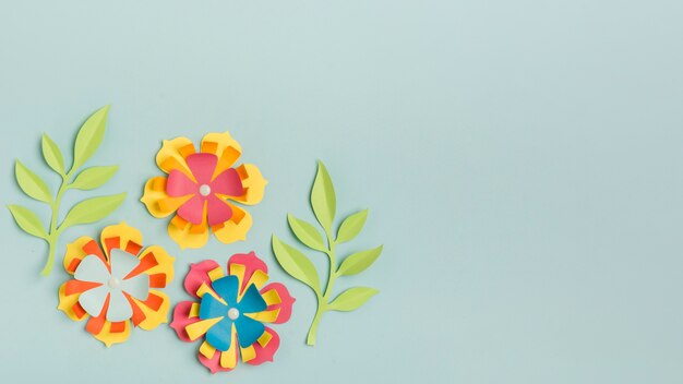 Beautifully colored paper spring flowers with copy space and leaves