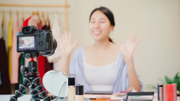 Beauty blogger present beauty cosmetics sitting in front camera for recording video. 