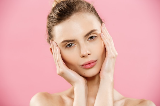 Free photo beauty concept - beautiful caucasian woman with clean skin, natural make-up isolated on bright pink background with copy space.