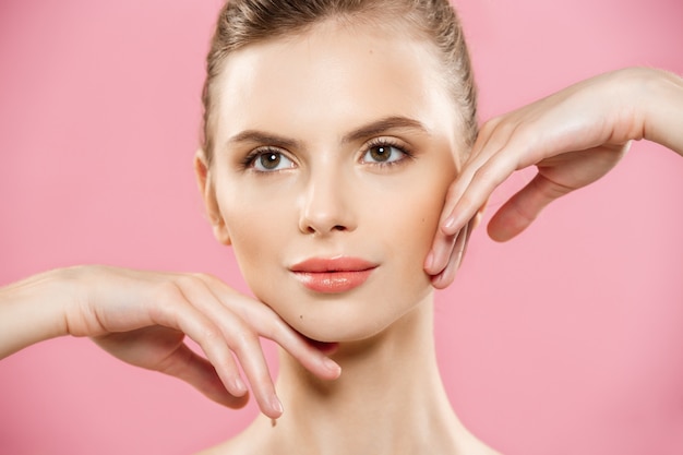 Beauty Concept - Beautiful Caucasian woman with clean skin, natural make-up isolated on bright pink background with copy space.