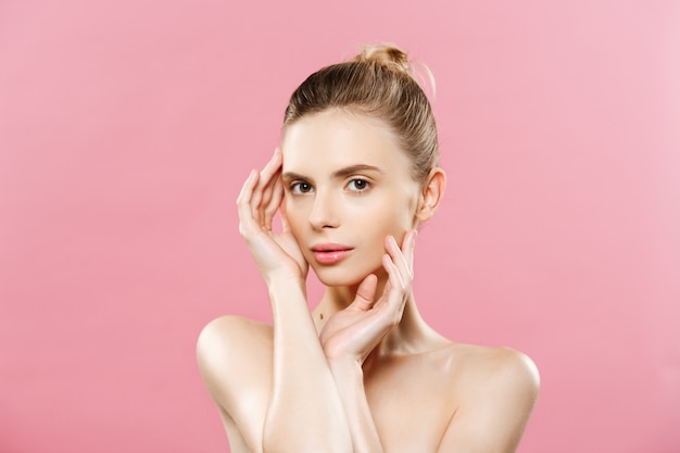 Free photo beauty concept - beautiful woman with clean fresh skin close up on pink studio. skin care face. cosmetology.