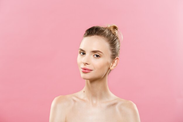 Beauty Concept - Beautiful Woman with Clean Fresh Skin close up on pink studio. Skin care face. Cosmetology.