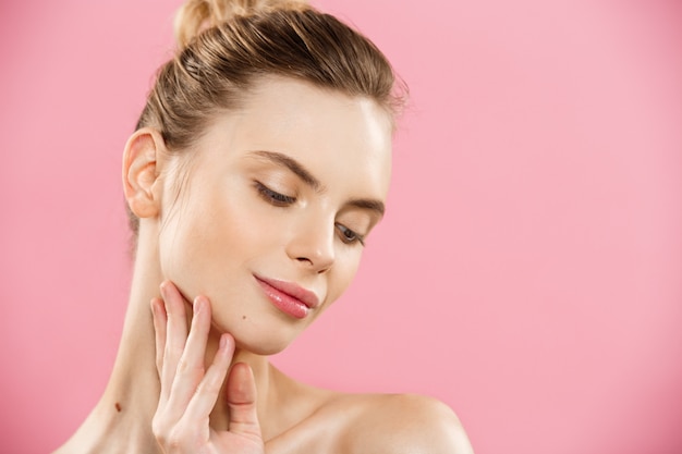 Free photo beauty concept - close up portrait of attractive caucasian girl with beauty natural skin isolated on pink background with copy space.