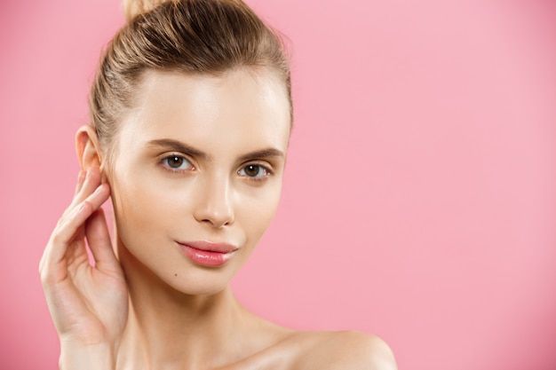 Free photo beauty concept - close up portrait of attractive caucasian girl with beauty natural skin isolated on pink background with copy space.