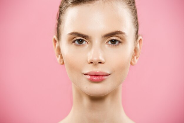 Beauty Concept - Close up Portrait of attractive caucasian girl with beauty natural skin isolated on pink background with copy space. 