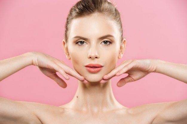 Free photo beauty concept - close up portrait of attractive caucasian girl with beauty natural skin isolated on pink background with copy space.