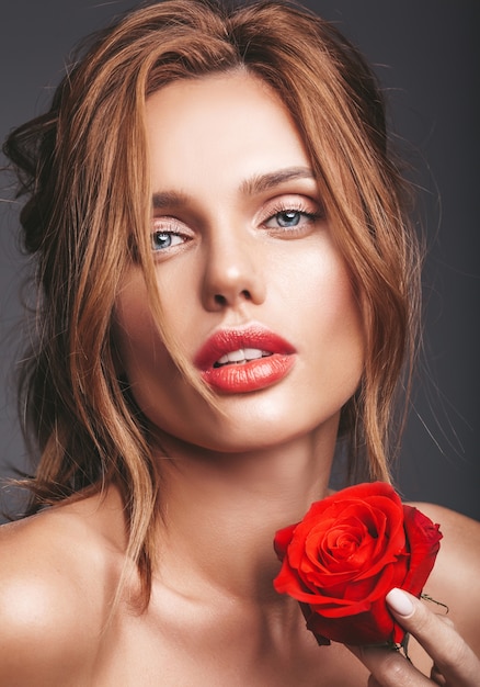 Beauty fashion portrait of young blond woman model with natural makeup and perfect skin with beautiful rose  posing