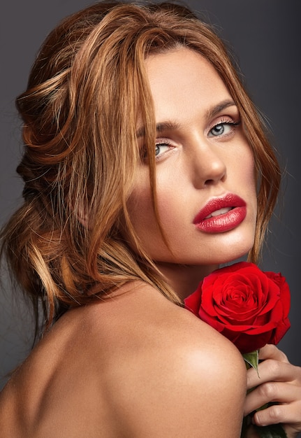 Beauty fashion portrait of young blond woman model with natural makeup and perfect skin with beautiful rose  posing