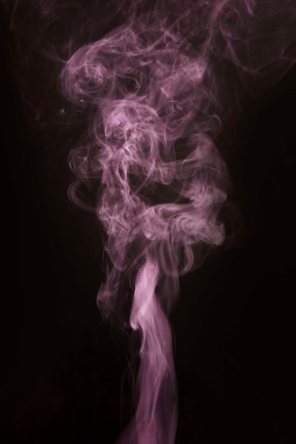 Beauty pink smoke moving upward on black background