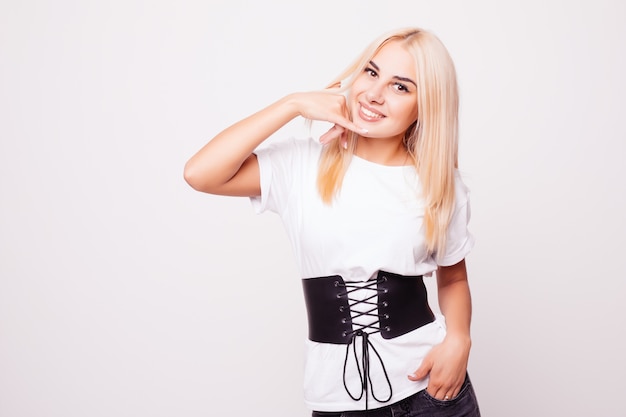 Free photo beauty portrait of blonde woman with call me back gesture on gray back