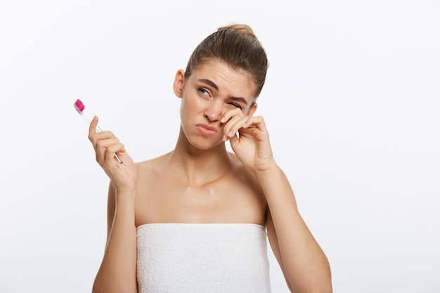 Beauty portrait of a happy beautiful half naked woman brushing her teeth with a toothbrush and looki