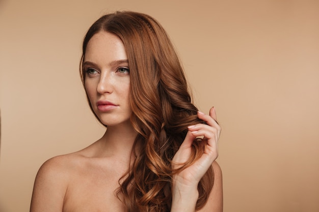 Free photo beauty portrait of pretty ginger woman with long hair posing and looking away