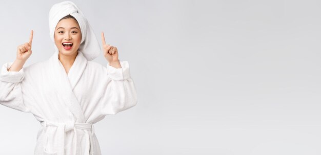 Beauty portrait of young woman showing and pointing finger to empty copy space asian beauty in bathrobe