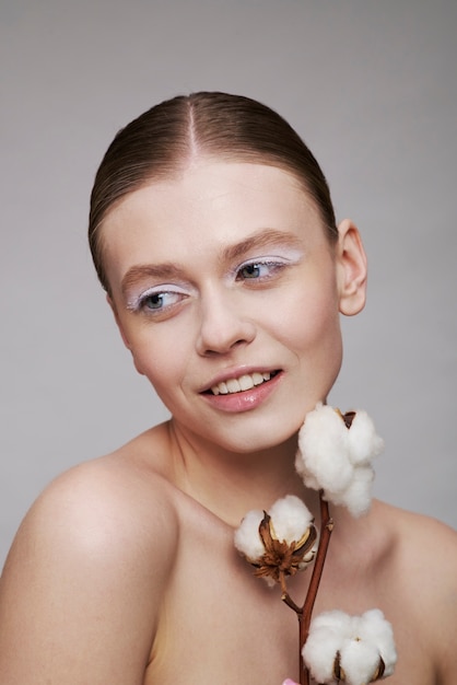 Beauty portrait of young woman with plant