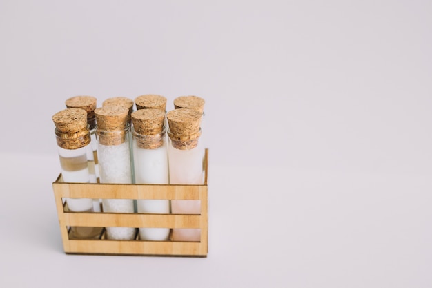 Free Photo beauty products test tubes in wooden container on white backdrop