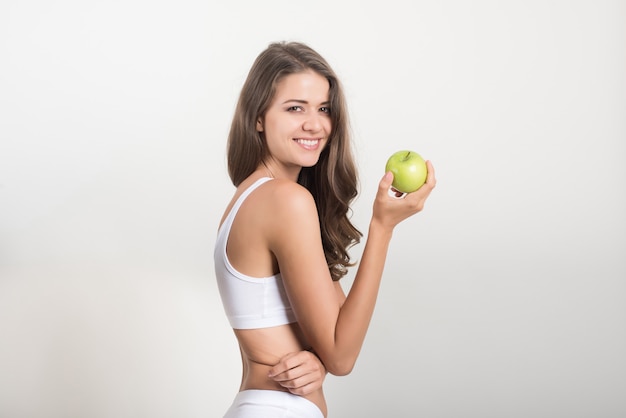 Beauty woman holding green apple while isolated on white