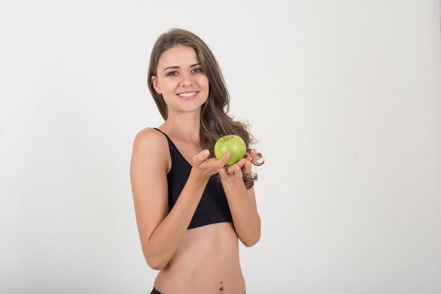 Beauty woman holding green apple while isolated on white