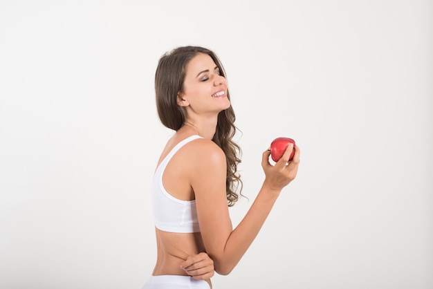 Beauty woman holding red apple while isolated on white