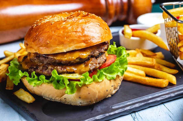 Beef burger meat lettuce tomato cheese french fries side view