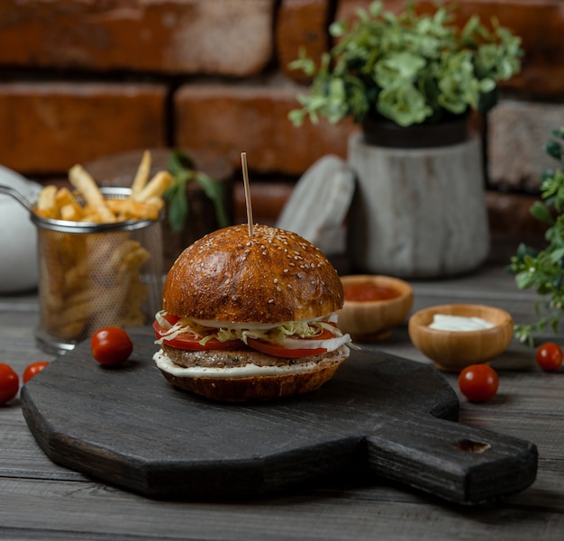 A beef burger stuffed with vegetables and apetizers and served with french fries.