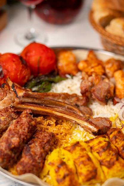 Beef, chicken kebab, bbq with roasted, grilled potatoes, tomatoes and served with rice.