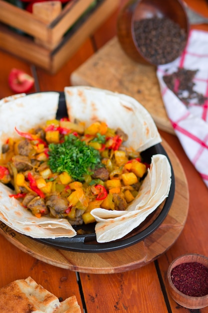 Beef meat stew with potatoes and chopped vegetables served with lavash    