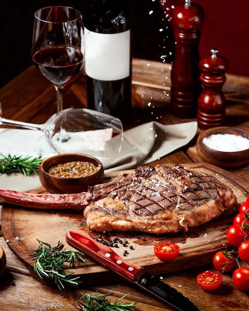 Free photo beef steak garnished with kosher salt on wood serving board