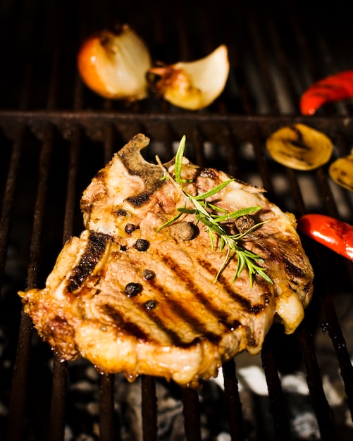 Free Photo beefsteak with spices and vegetables on grill