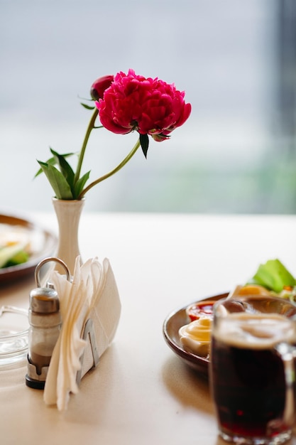 Beer cup standing near appetizers plate Dark beer with thick high foam Standing on smooth wooden surface of restaurant's or pub table Looking mouthwatering Cold and fresh For friends company