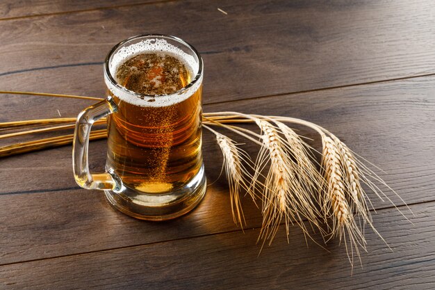 Beer in a glass mug with wheat ears high angle view on a wooden table