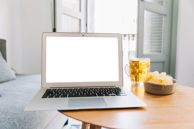 Beer and potato chips near laptop