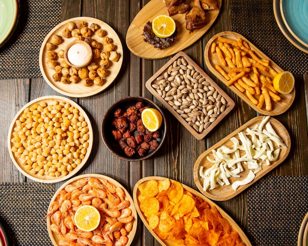 Beer snacks plates of fried dushbara shrimps boiled chickpeas pistachio chips string cheese