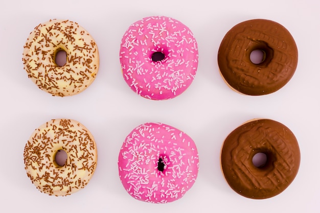 Free photo beige; pink and brown donut on white background