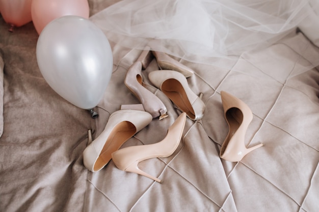 Free photo beige shoes are lying on the blanket near veil and balloons